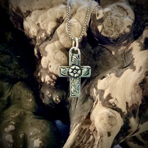 Sterling silver cross pendant with a sculpted flower in center.